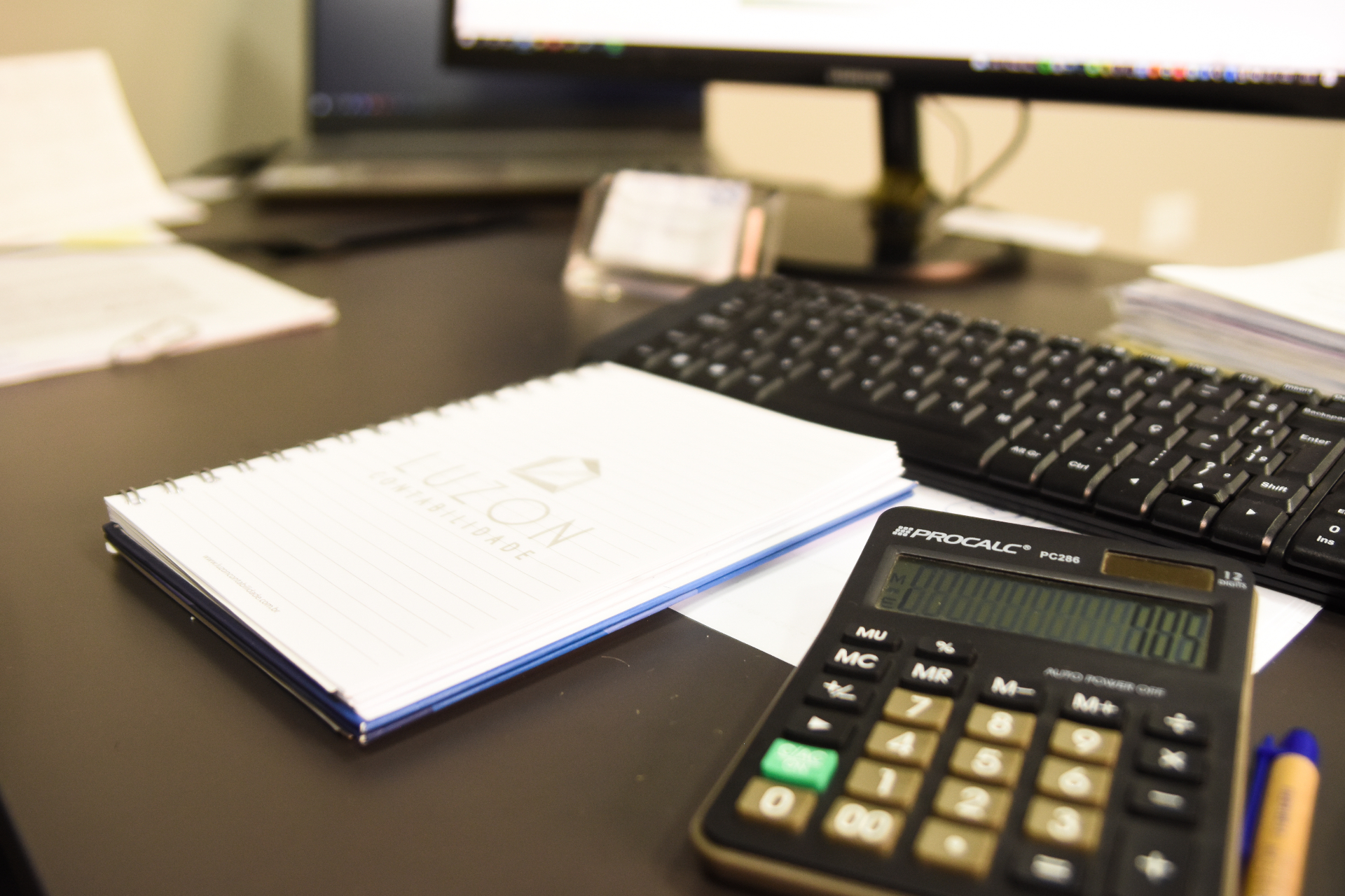 Ambiente de trabalho Luzon Contabilidade com calculadora, caderno e computador